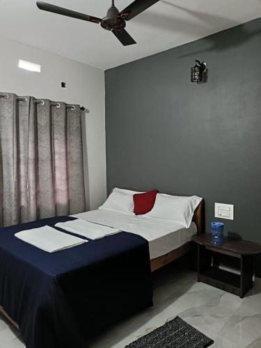 a bedroom with a bed with a ceiling fan at Coorg wildstone Homestay in Madikeri