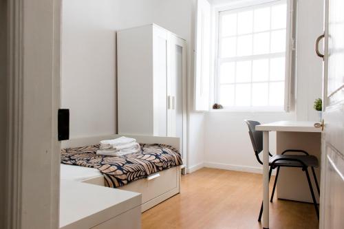 a bedroom with a bed and a desk and a window at Santos Stay by Madrabica in Lisbon