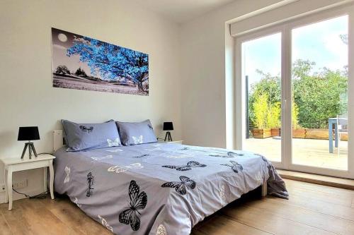 a bedroom with a bed and a large window at Appart avec terrasse jardin ds mais ind Nomexy in Nomexy