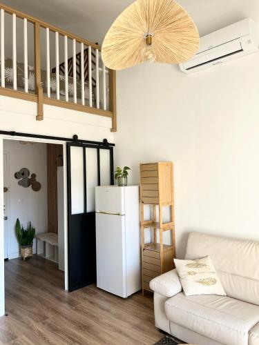 - un salon avec un réfrigérateur blanc et un canapé dans l'établissement Appart bord de mer vu montagne, à Banyuls-sur-Mer
