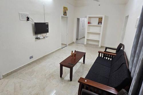 a living room with a couch and a coffee table at HOMESTAY - AC 3 BHK NEAR AlRPORT in Chennai