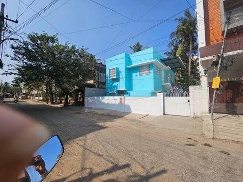 a blue house on the side of a street at HOMESTAY - AC 3 BHK NEAR AlRPORT in Chennai