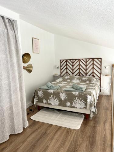 - une chambre avec un lit et un tapis sur du parquet dans l'établissement Appart bord de mer vu montagne, à Banyuls-sur-Mer