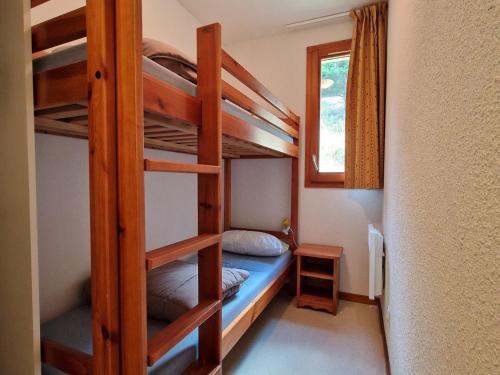 une chambre avec deux lits superposés et une fenêtre dans l'établissement Charmant appartement pour 8 pers avec équipements modernes à Valfréjus - FR-1-265-167, à Valfréjus