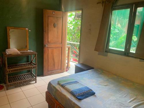 a bedroom with a bed and a mirror and a door at Hostal Mamacucha in Montañita