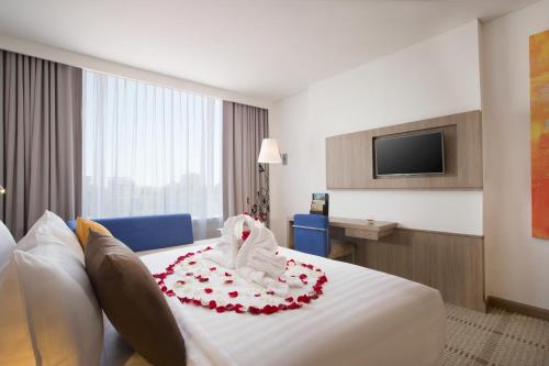 a hotel room with a bed with a stuffed animal on it at Novotel Makassar Grand Shayla in Makassar