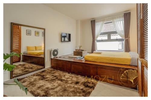 a bedroom with a bed and a large mirror at Aki 秋 Hostel in Da Lat