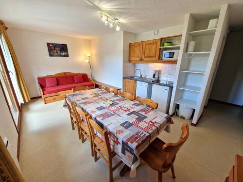 une cuisine et une salle à manger avec une table et des chaises dans l'établissement Charmant appartement pour 8 pers avec équipements modernes à Valfréjus - FR-1-265-167, à Valfréjus