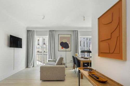 a living room with a chair and a table at Les Deux Mariettes Apartments & Suites in Lisbon