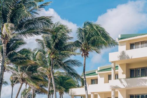 a building with palm trees in front of it at Iberostar Selection Cancun - All Inclusive in Cancún
