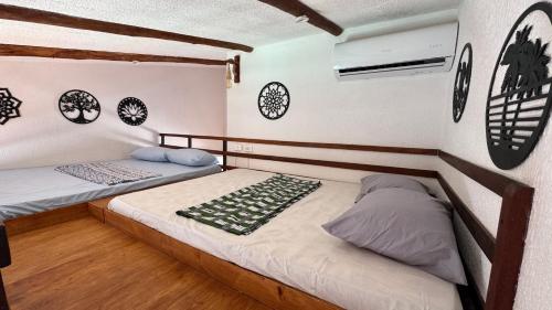 two beds in a room with clocks on the wall at Bangalô com tudo privativo em Tamandaré/PE in Tamandaré