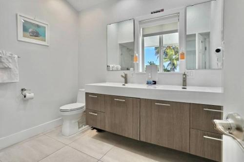 a bathroom with a sink and a toilet and a mirror at Palms Resort Main House - Key West in Sugarloaf Shores