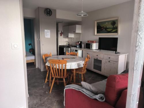 una cocina con una mesa y algunas sillas y una cocina con una mesa en Charmant studio, en Le Tholy