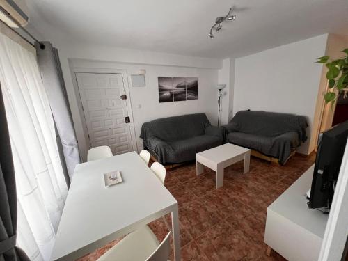 ein Wohnzimmer mit Sofa und Tisch in der Unterkunft Apartamento en el centro de Nerja in Nerja