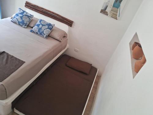 a small bed in a small room with a small drawer at Hotel Posada Mykonos in Bacalar
