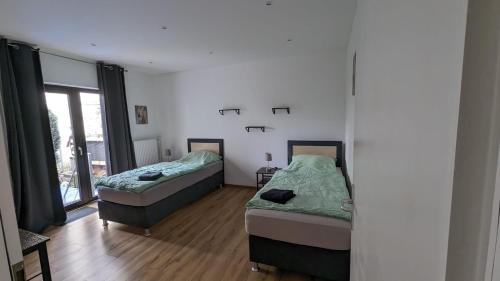 a room with two beds and a window at Rheinische Gemütlichkeit, Sali Homes Zentrales Heim in Kleve in Kleve