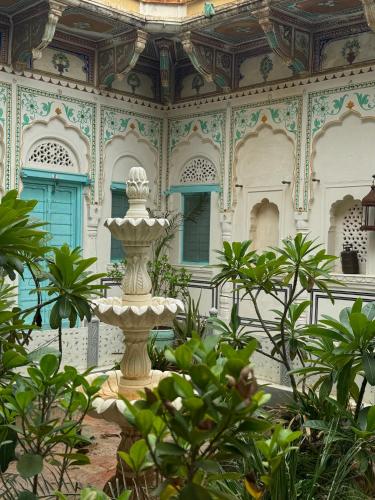 a fountain in the middle of a building with plants at Mandawa Kothi in Mandāwa