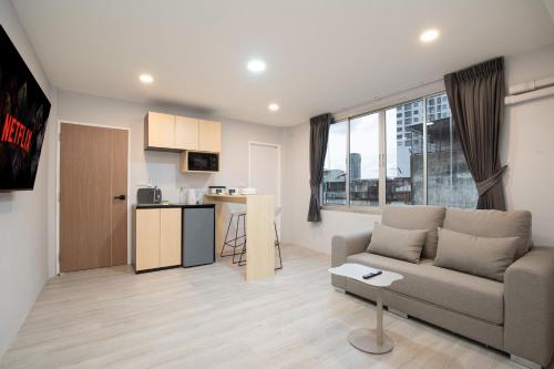 a living room with a couch and a kitchen at Wash House Chatuchak in Bangkok
