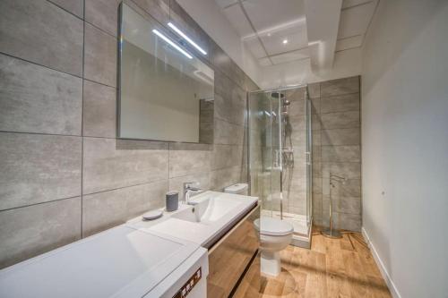 a bathroom with a sink and a toilet and a shower at F1 tout équipé-neuf-tout confort in Saint-Martin-dʼHères