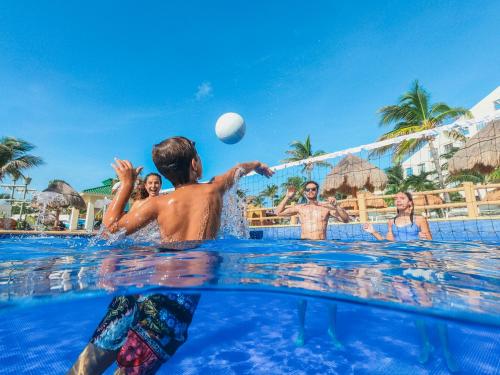 a group of people playing with a ball in the swimming pool at Iberostar Selection Cancun - All Inclusive in Cancún