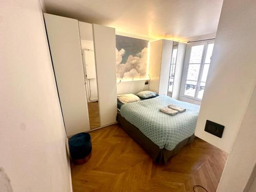 une petite pièce avec un lit et une fenêtre dans l'établissement Home Sweet Home Champs de Mars, à Paris