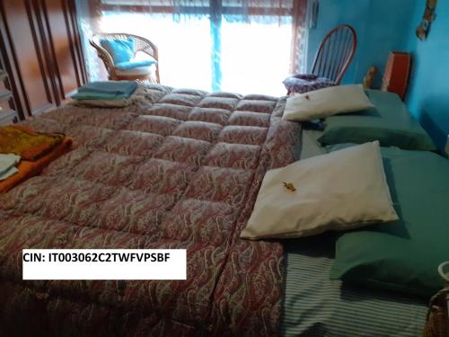 a bedroom with a bed with a comforter and a window at Room country-lake in Dormelletto