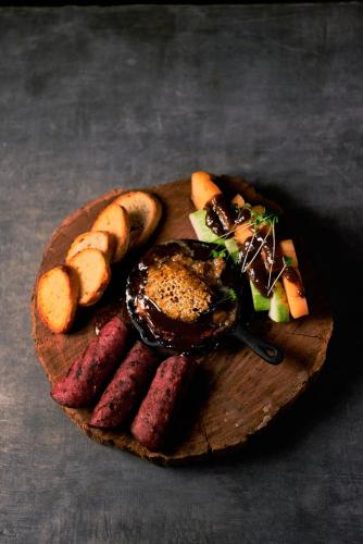a plate of food with sausage and vegetables on a table at Hidden Valley Wilderness Lodge in San Ignacio