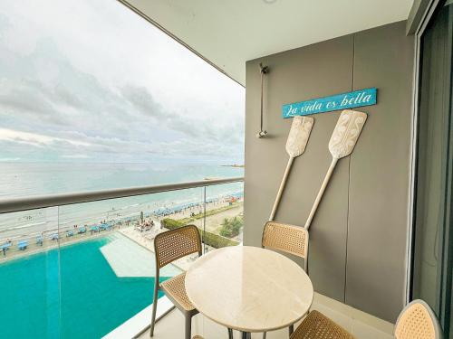 a table and chairs in a room with a view of the ocean at Namaste Alojamientos Luxury Cartagena in Cartagena de Indias