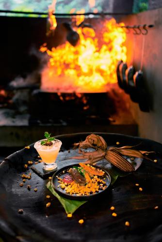 a grill with a plate of food and a drink at Hidden Valley Wilderness Lodge in San Ignacio
