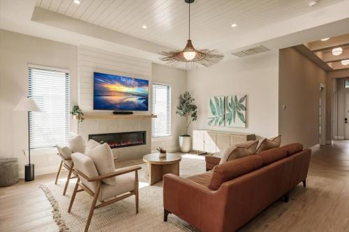 ネープルズにあるNaples Paradise Cove Luxury Beach Homeのソファと椅子と暖炉のあるリビングルーム