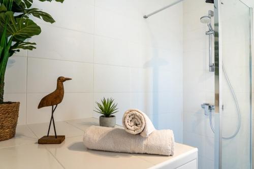 La salle de bains est pourvue d'une douche et d'une statue d'un oiseau. dans l'établissement L'Escapade en Vieille Ville, à Annecy