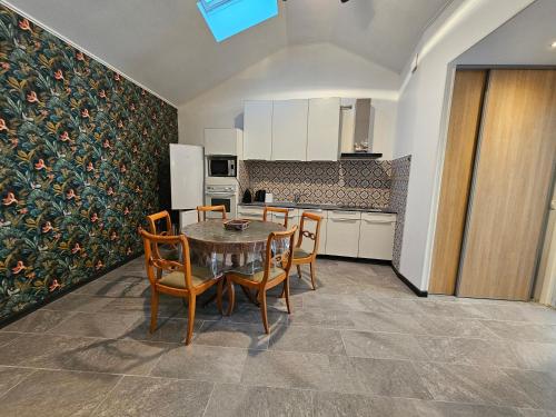 une cuisine avec une table et des chaises dans une pièce dans l'établissement Disney 1, à Mouroux