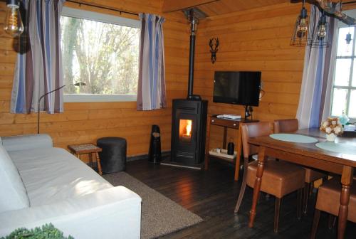 a living room with a wood stove and a table at Luxe blokhut Warnstee in Wichmond