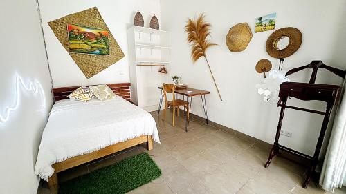 a small bedroom with a bed and a table at Black Pillow Villa in Jimbaran