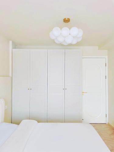 a bedroom with white cabinets and a white bed at Flaneur Shanghai Hongqiao B&B Near National Exhibition and Convention Center in Shanghai