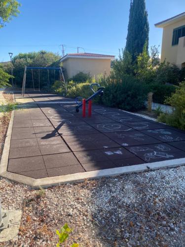 a playground in a yard with a swing at William and Emily Apartment in Polis Chrysochous