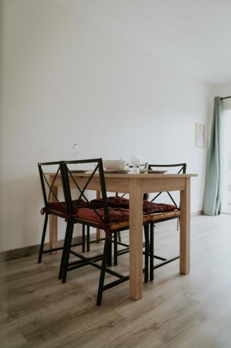 a dining room table with a chair and a table at F2 spacieux et lumineux avec cuisine équipée in Saint-Genest-Lerpt