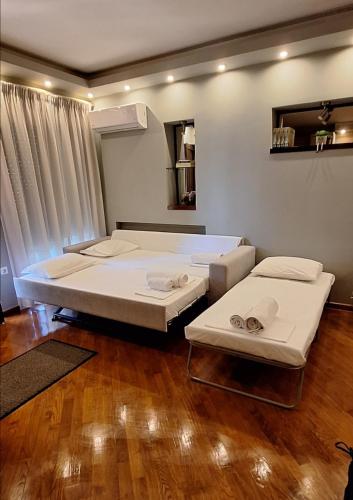two beds in a room with wooden floors at Home Spot Nafplio in Nafplio
