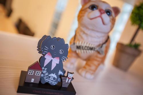 a figurine of a cat sitting next to a house at Cat Walk貓步民宿 in Puli