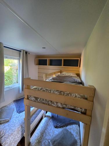 Cette petite chambre dispose de 2 lits superposés et d'une fenêtre. dans l'établissement Mobil-home Beau Rivage, à Gunsbach