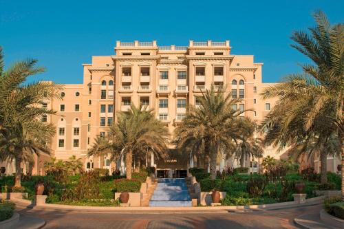 a large building with palm trees in front of it at The Westin Dubai Mina Seyahi Beach Resort and Waterpark in Dubai