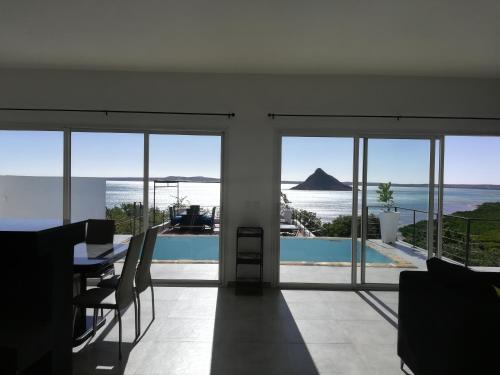 a dining room with a table and views of the ocean at Résidence ÉBÈNE - Villas in Antsakomboena
