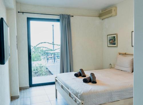 Un dormitorio con una cama y una ventana grande. en Deck House, en Pefkali