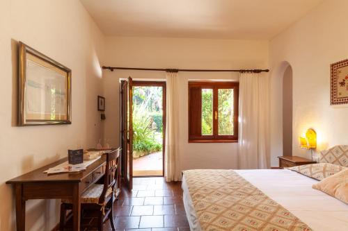 a hotel room with a bed and a desk and a window at Nora Club Hotel & Spa in Pula