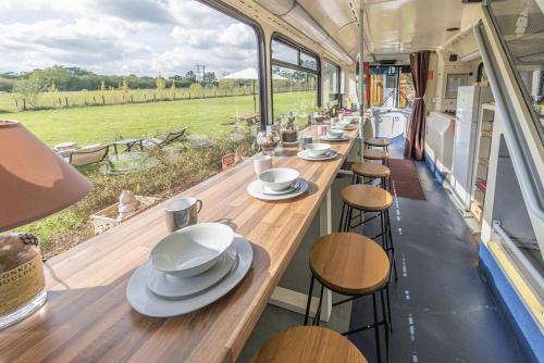 a line of tables and chairs in a food truck at Double Decker Bus on an Alpaca farm sleeps 8, 5 mins drive to Dartmoor in Bovey Tracey