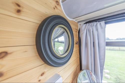 a round window on the wall of a tiny house at Double Decker Bus on an Alpaca farm sleeps 8, 5 mins drive to Dartmoor in Bovey Tracey
