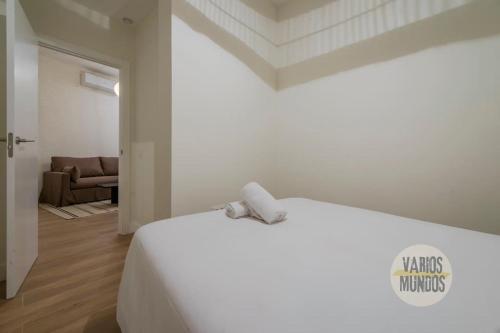 a white bed in a room with a couch at Cozy y Céntrico Apt para 6pax en Plaza del Carmen E2 in Madrid