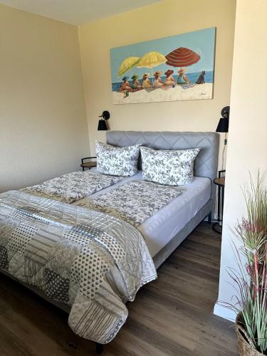 a bedroom with a bed and a painting of people on the beach at Min Öömrang Lun in Wittdün