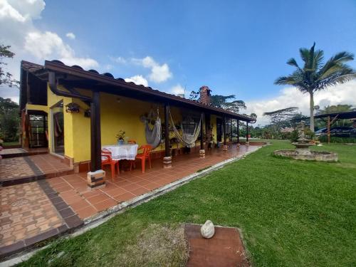 a yellow house with a table in a yard at Casa Campo Los Lucero, con Hidrospa in Piedecuesta