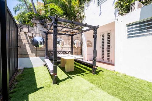 a garden with a swing in a yard at 24 Atlantic Place by Stay with Bear in San Juan